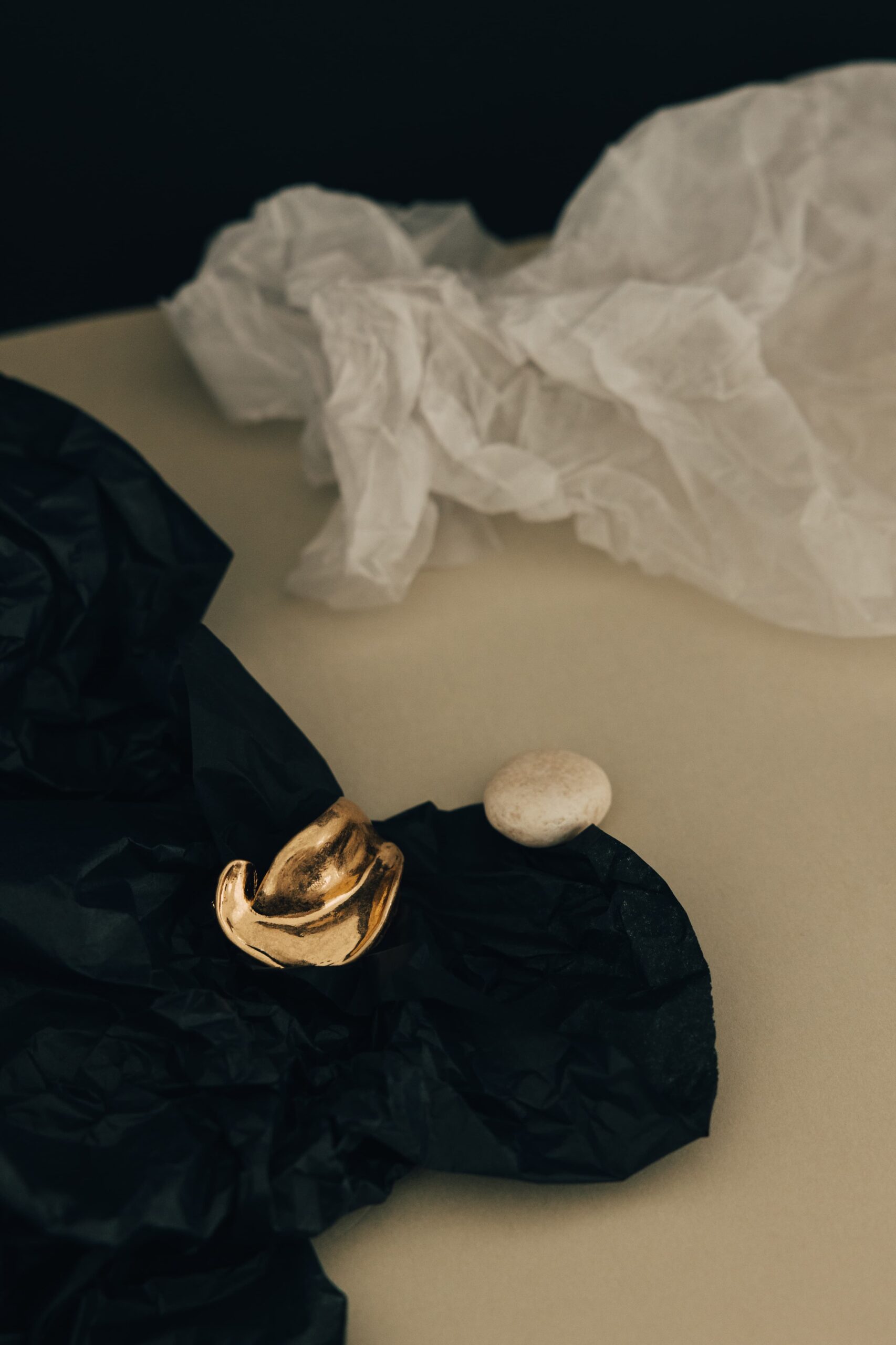 Gold object resting on black tissue paper